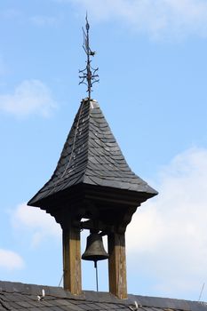 a small bell tower with blue sky in background