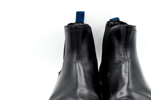 close up of a pair of black mens leather chelsea boots isolated on white background