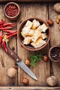 Feta cheese with spice and garlic on old wooden background