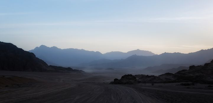 night desert landscape with rocky mountains and sunset sky with clouds in Sharm El Sheikh Egypt