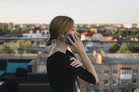 Young business woman using smart mobile phone, outside office building and speaking with a business partners. Business lady answering the phone with a smile, receiving good news. Freelancer