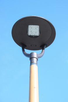 A street lamp, blue sky in the background