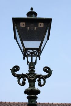 A decorated street lamp, blue sky in the background