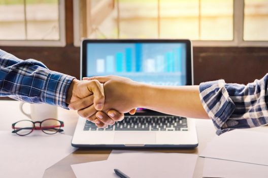 businesspeople shaking hands to seal a deal with his partner  in office. Teamwork , hipster tone