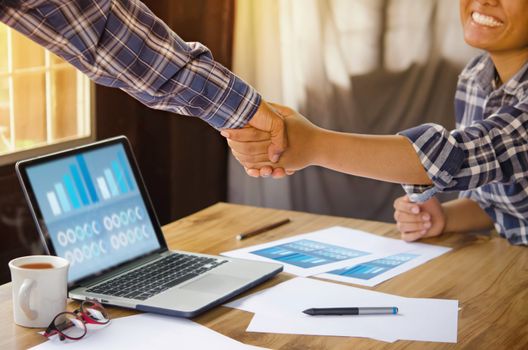 businesspeople shaking hands to seal a deal with his partner  in office. Teamwork , hipster tone