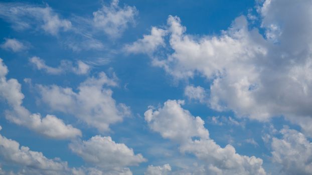 White fluffy clouds on a blue sky background