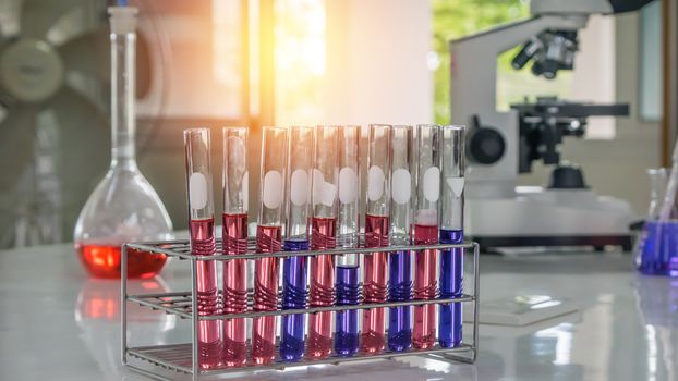 Different laboratory test tubes with colored liquid and with reflection