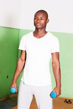 Young man holding weights in the hands in the gym and ready to lift them.