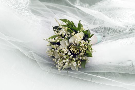 Wedding bouquet on a background of a veil