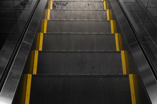 Empty escalators stairway with a yellow stripes