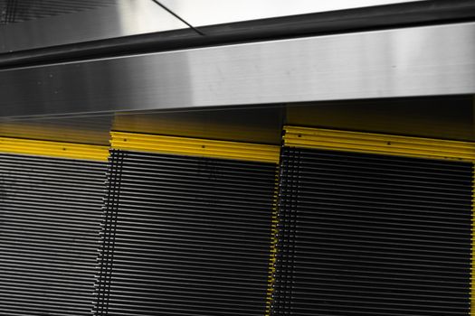 Empty escalators stairway with a yellow stripes