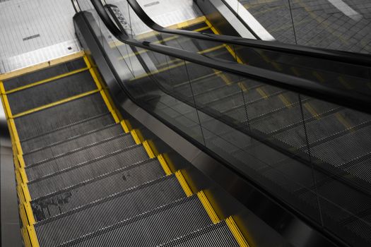 Empty escalators stairway with a yellow stripes