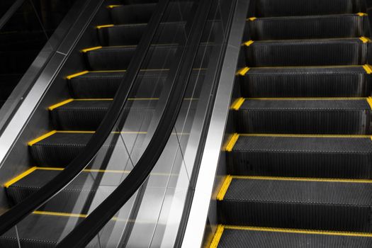 Empty escalators stairway with a yellow stripes