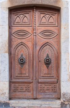 Old wooden decorative door in medieval Old Town - Vila Vella Spain, Tossa de Mar.