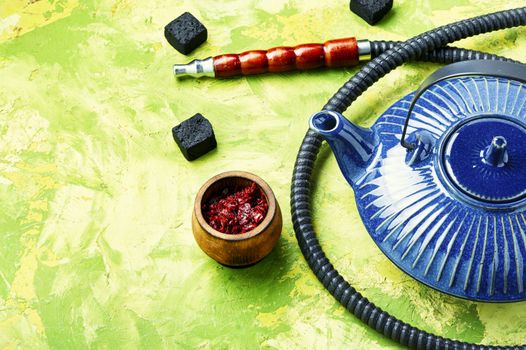 Details of tobacco hookah and teapot with tea.Egyptian smoking shisha and teakettle