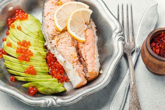 Boiled salmon or trout with avocado garnish.Diet fish.