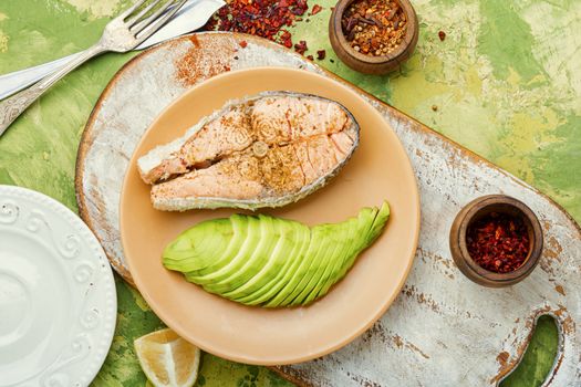 Boiled salmon or trout with avocado garnish.Diet fish.