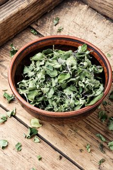 Bowl of dried oregano leaves on wooden background.Dried oregano seasoning