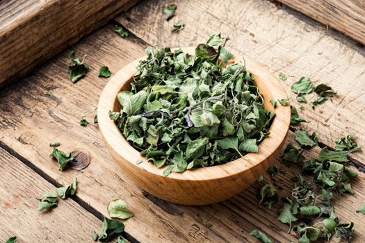 Bowl of dried oregano leaves on wooden background.Dried oregano seasoning.Oregano or marjoram leaves