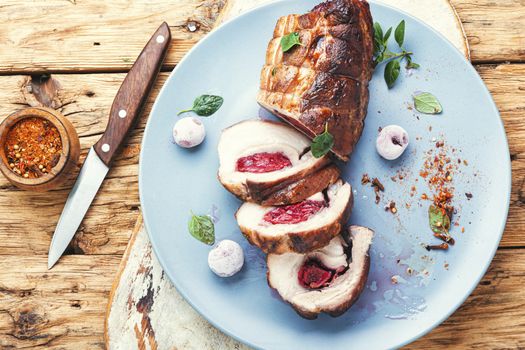 Roasted pork with cherry filling on plate.Baked pork.