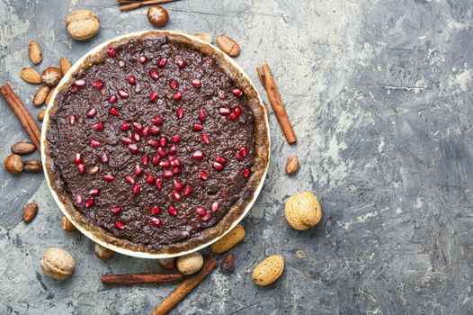 Tasty homemade chocolate cake with pomegranate and nut.