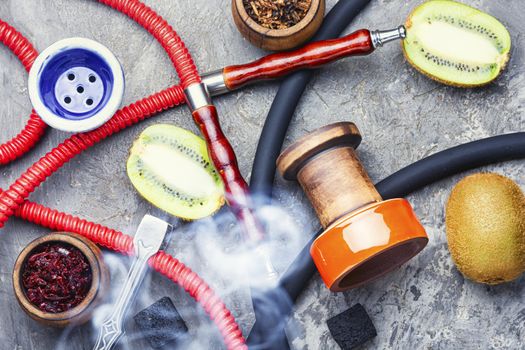 Turkish tobacco hookah on kiwi.Fragrant oriental hookah.Details of a smoking hookah.Fruit tobacco for hookah.