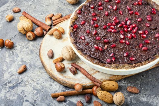 Tasty homemade chocolate cake with pomegranate and nut.