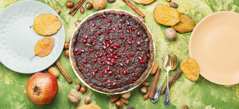 Tasty homemade chocolate cake with pomegranate and nut.