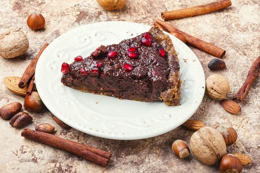 Tasty homemade chocolate cake with pomegranate and nut.