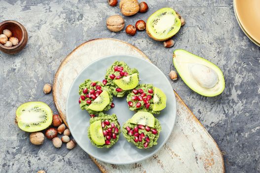 Diet avocado cupcakes garnished with kiwi and pomegranate.American fairy cake