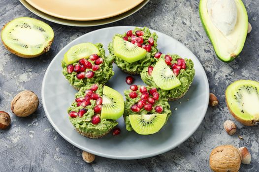 Diet avocado cupcakes garnished with kiwi and pomegranate.Fairy cake