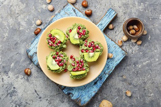 Diet avocado cupcakes garnished with kiwi and pomegranate.Fairy cake