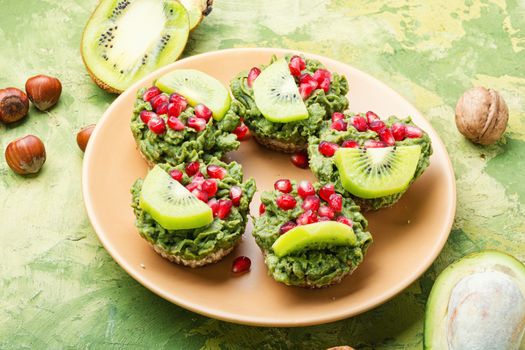 Diet avocado cupcakes garnished with kiwi and pomegranate