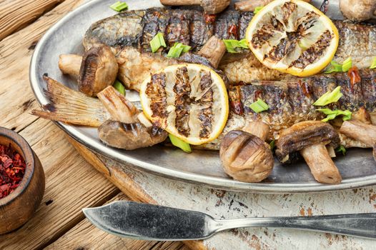 Baked whole pelengas fish with mushrooms and lemon.Sea food.Grilled fish with mushrooms.