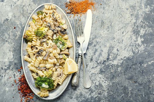 Baked broccoli and pasta with mushrooms.Italian food