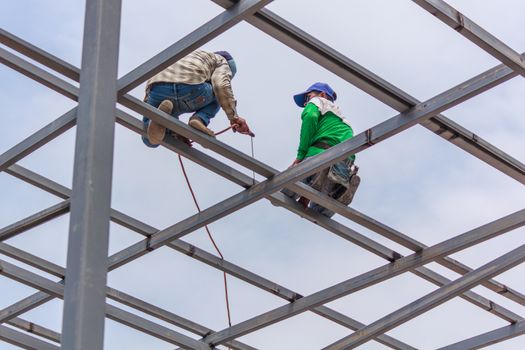 Welder welding fabricated construction in building, Welding process by Stick Welding, No safety Belt, No Mask, No Glove