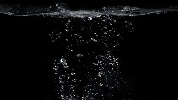 Blurred images of close-up soda water bubbles fizzing up or splashing or sparkling like a exploding of a bomb on black background for represent refreshing from carbonated drinks menu.