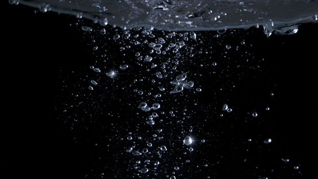 Blurred images of close-up soda water bubbles fizzing up or splashing or sparkling like a exploding of a bomb on black background for represent refreshing from carbonated drinks menu.