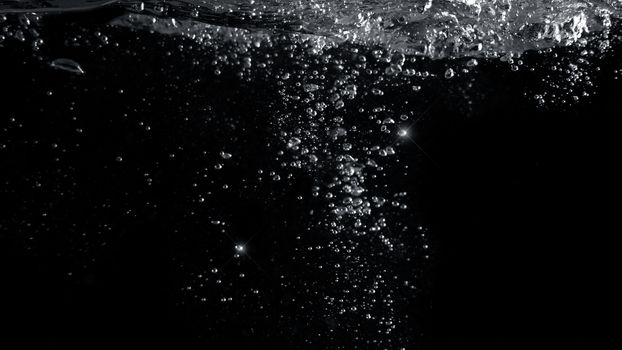 Blurred images of close-up soda water bubbles fizzing up or splashing or sparkling like a exploding of a bomb on black background for represent refreshing from carbonated drinks menu.