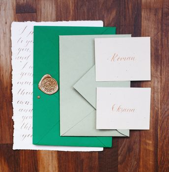 Wedding details flat lay. Wedding invitation. Wooden background. Wedding bouquet. Copy space. Mock up. Envelope.