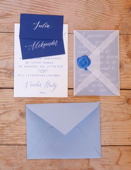 Wedding details flat lay on wooden background. Wedding invitation. Wedding bouquet. Copy space. Mock up. Envelope.