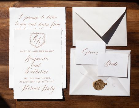Wedding details flat lay on wooden background. Wedding invitation. Wedding bouquet. Copy space. Mock up. Envelope.
