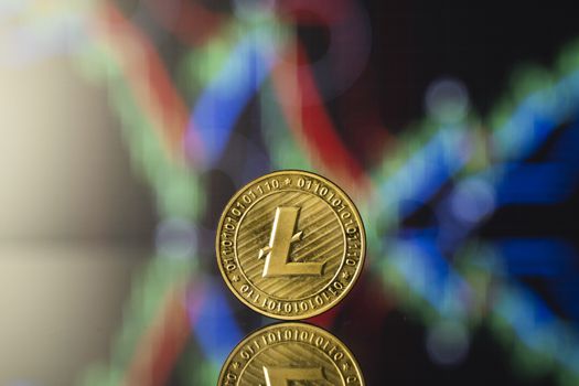 Litecoin and virtual money concept. Gold bitcoins with chart of growing and falling valuance of a cryptocurrency. Mining or blockchain technology. Mining of bitcoins online bussiness. Trading