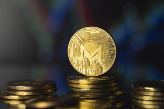 Monero and virtual money concept. Gold monero bitcoins on a stack of coins with chart of growing and falling valuance of a cryptocurrency. Mining or blockchain technology