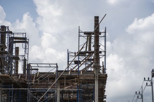 Building and Construction Site in progress. Building construction site against cloudy sky. Metal construction of unfinished building on construction of multi storage building