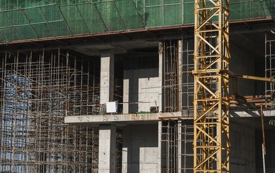 Building and Construction Site in progress. Building construction site against blue sky. Metal construction of unfinished building on construction of multi storage building