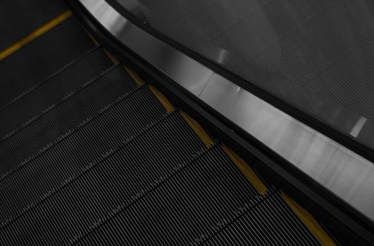 Modern escalator electronic system moving. Escalator is moving up.The ground is a straight line. Black with yellow band