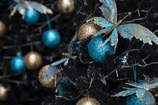 Decorated Christmas tree with a blue and gold toys and beautiful blue butterfly toy. Holidays. Preparation for New Year and Christmas