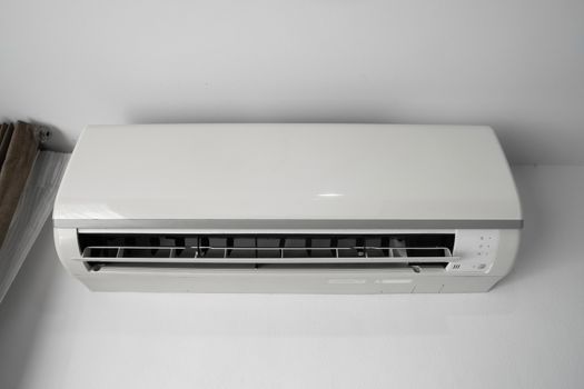 Air conditioner mounted on a white wall in the living room or bedroom. Indooor comfort temperature. Health concepts and energy savings