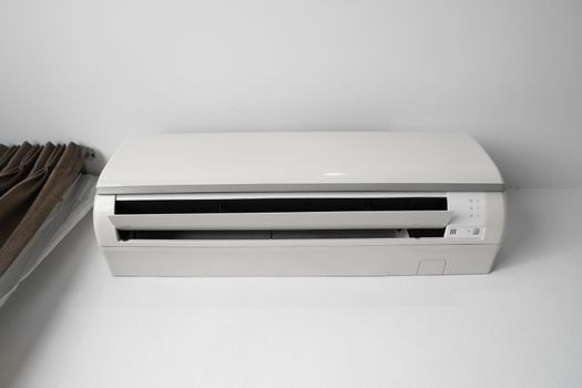 Air conditioner mounted on a white wall in the living room or bedroom. Indooor comfort temperature. Health concepts and energy savings